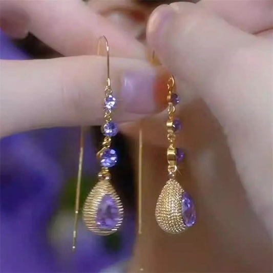 Shine with elegance in Glam Sleek’s Elegant Purple Crystal Waterdrop Long Tassel Ear Line Earrings. Featuring sparkling purple crystals and a delicate tassel ear line design, these lightweight statement earrings add sophistication to evening wear, parties, and special occasions. Perfect for women who love trendy, stylish, and modern jewelry, these waterdrop dangle earrings combine glamour with comfort for a timeless fashion accessory.