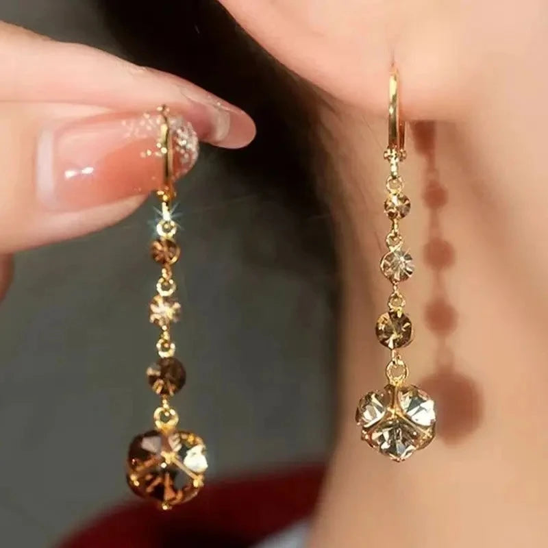 Add a touch of elegance to your look with Glam Sleek's Brown Rhinestone Ball Zircon Tassel Earrings. These stunning earrings feature shimmering rhinestones and delicate zircon accents, cascading into graceful tassels. Perfect for elevating any outfit, their chic design blends sophistication with a hint of sparkle, making them ideal for special occasions or everyday glamour.