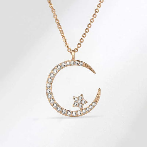 Rose gold necklace with crescent moon and star pendant on a light gray background