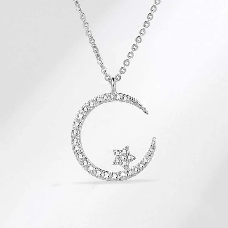 Silver necklace with a crescent moon and star pendant on a light gray background