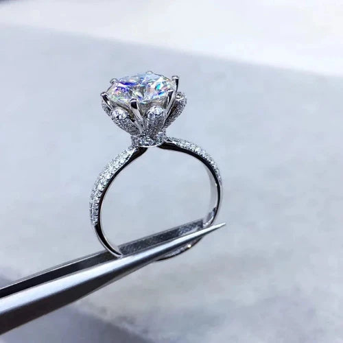 The *Sparkling Moissanite Flower Ring* by **Glam Sleek** is a stunning symbol of love and elegance. Featuring a radiant moissanite stone set in a delicate flower design, this ring captures light with breathtaking brilliance. Perfect for a promise, engagement, wedding, or anniversary, it combines timeless beauty with modern sophistication. Crafted with precision, it's a meaningful statement of forever.