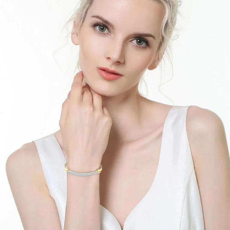 Introducing the **Shining White Crystal Bangle** by *Glam Sleek* – a stunning blend of elegance and modern sophistication. This beautifully crafted bangle features shimmering white crystals set in a sleek, minimalist design, perfect for adding a touch of glamour to any outfit. Lightweight and versatile, it's the ideal accessory for both casual and formal occasions. Elevate your style effortlessly with this sparkling statement piece.